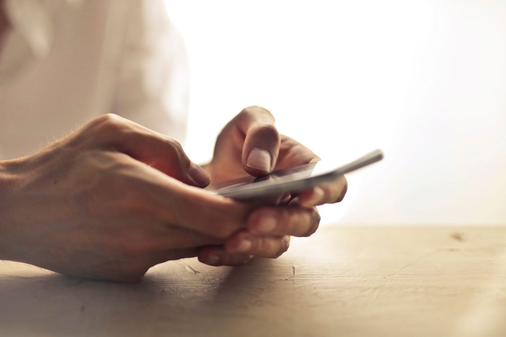IELTS Speaking Part 1 technology questions: hands holding a smartphone