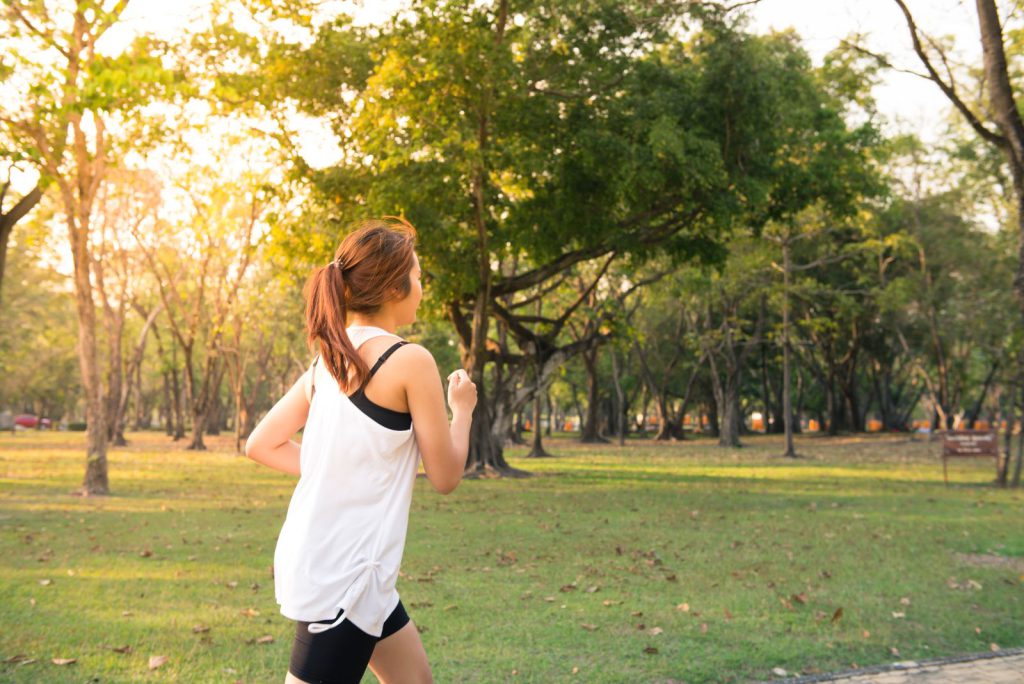 IELTS Speaking Part 2 health and fitness cue cards: a woman running in a park